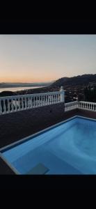 a swimming pool on the side of a white fence at Zoe's house Salamina in Salamís