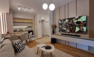 a living room with a couch and a tv at Luxury Gold Apartment in Skopje