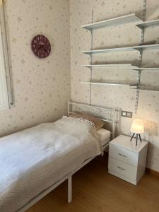 - une chambre avec un lit, une table de chevet et une horloge dans l'établissement Seaside cottage, à Pobla de Montornés 7 autres photos