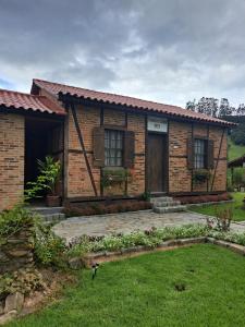 a brick house with a yard in front of it at Caminhos da Serra do Tabuleiro - Casa Centenária Enxaimel 1915 in São Bonifácio