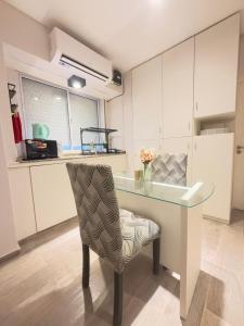 una cucina con tavolo in vetro e sedia di DEPARTAMENTO en MICROCENTRO a Corrientes Altre 7 foto