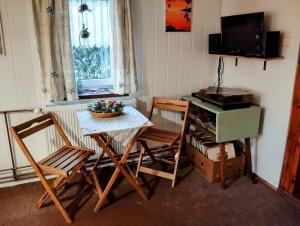 a room with a table and chairs and a television at Chata Koza in Bublava