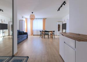 a kitchen and living room with a couch and a table at Miriam Apartment Kraków Borkowska - Parking in Kraków