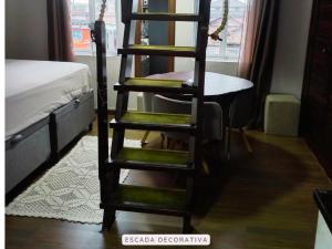 a ladder in a room with a bed and a desk at Castelinho Solemar - Apart Premium a Passos da Praia in Praia Grande +8 photos