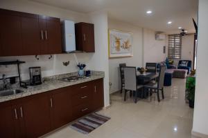 Una cocina con una mesa y un comedor. en 2BR-3BA Condo Block from Beach w Rooftop Jacuzzi, en Mazatlán