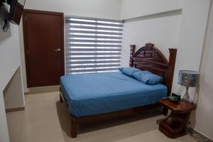 Un dormitorio con una cama con sábanas azules y una ventana. en 2BR-3BA Condo Block from Beach w Rooftop Jacuzzi, en Mazatlán 21 fotos más