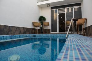 una piscina con sillas y una casa en 2BR-3BA Condo Block from Beach w Rooftop Jacuzzi, en Mazatlán