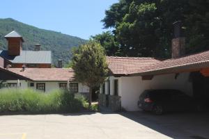 un coche aparcado frente a una casa en Apart Rose Garden en San Martín de los Andes