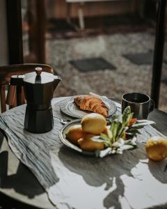 a table with a plate of bread and a coffee pot at Braithwaite Hobart - Chic Retreat with Outdoor Bath in Hobart