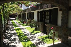 an alley in a building with grass and flowers at Apart Rose Garden in San Martín de los Andes