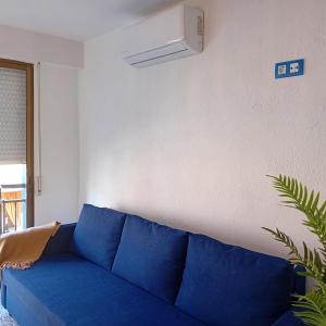 a blue couch in a living room with a white wall at María PLAYA 1 NG in Peniscola