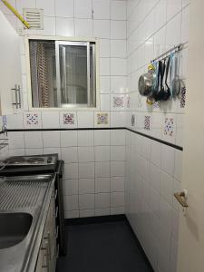 a white tiled kitchen with a sink and a window at Corazón obelisco 3 in Buenos Aires +14 photos