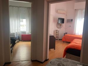 a room with a bedroom with two beds and a television at Corazón obelisco 3 in Buenos Aires