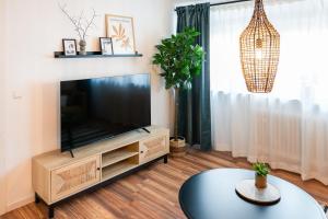 a living room with a flat screen tv and a table at MARKT14 City Apartment Marktplatz Freundenstadt in Freudenstadt
