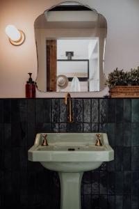 a bathroom with a sink and a mirror at Braithwaite Hobart - Chic Retreat with Outdoor Bath in Hobart