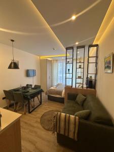 a living room with a couch and a table and a bed at Apartman B64 Residence Hill Kopaonik in Kopaonik