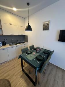 a kitchen with a table with a green table cloth on it at Apartman B64 Residence Hill Kopaonik in Kopaonik