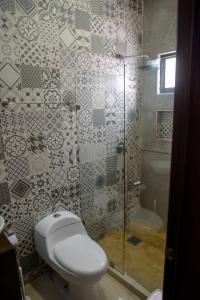 a bathroom with a toilet and a glass shower at 2br/2ba Condo 1 block to ocean! - Unit 6 in Mazatlán +22 photos