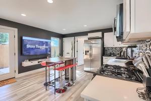 a kitchen with a refrigerator and a counter with stools at East Side 3BR Masterpiece Home in Austin