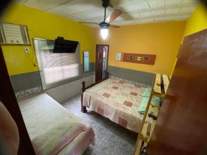 a bedroom with two beds and a tv in it at Sun House in Saquarema +27 photos