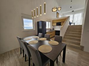 a dining room with a black table and chairs at Luxury Loft Apartment Mandre in Mandre