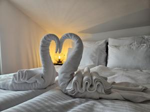 two swans towels are sitting on a bed at Luxury Loft Apartment Mandre in Mandre