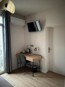 a desk in a room with a television on the wall at Hotel Restaurant Les Paquebots in Port-Vendres +13 photos