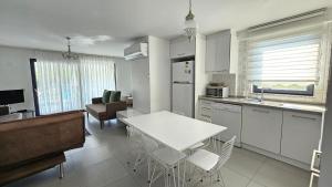 a kitchen and living room with a white table and chairs at Villa Zümrüt in Ortaca