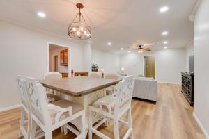a dining room with a wooden table and white chairs at Walking Distance to Casino Home in Westlake! in Westlake