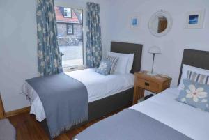 a bedroom with two beds and a window at 244 Seatown Cullen Moray Scotland in Cullen