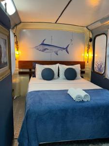 a bedroom with a bed with a fish painting on the wall at Hospedagem no Ônibus Navy na Praia da Baleia - Jacaraípe in Serra +17 photos