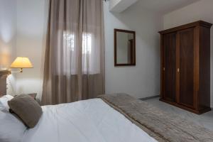 a bedroom with a bed and a cabinet and a mirror at Royal Garden in Massa dʼAlbe