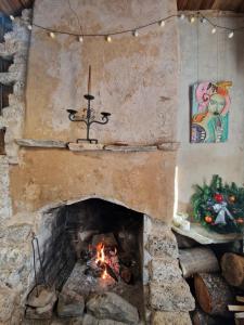 a stone fireplace with a fire in it at Вила 'Гнездото', Villa 'The nest', Rhodope mountains, Banite in Vishnevo +34 photos