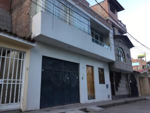ein Gebäude mit zwei Garagentoren an einer Straße in der Unterkunft Depa en 1er piso,cochera, close to the plaza and UNSCH in Ayacucho
