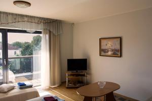 - un salon avec une télévision et une grande fenêtre dans l'établissement Holiday Apartment Pikk, à Pärnu