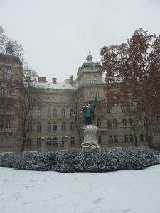 a statue in the snow in front of a building at Flat On Andrássy Avenue in Budapest
