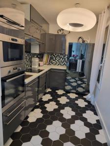 サン・トゥアンにあるChambre cosy près de Paris dans un appartement partagéの白黒のチェック柄の床のキッチン