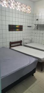 a room with two beds in a room at Quarto com cozinha funcional in Guarapari
