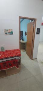 a room with a bed and an open door at Quarto com cozinha funcional in Guarapari