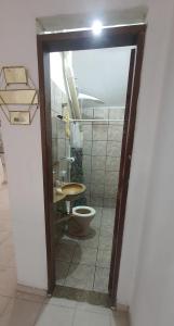 a bathroom with a toilet in a room at Quarto com cozinha funcional in Guarapari