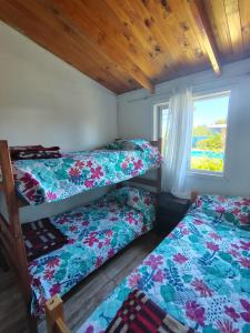 ein Schlafzimmer mit zwei Etagenbetten und einem Fenster in der Unterkunft Cabaña Bungalow SPA pasaje Las Pataguas in Quillón + 10 Fotos