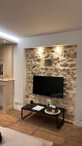 ベラックにあるStudio cosy idéal pour Séjours Courts ou Longsの石壁のリビングルーム(テレビ付)