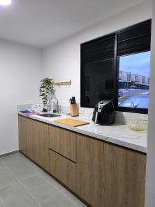 cocina con encimera y ventana grande en Edén Tropical, en La Tebaida