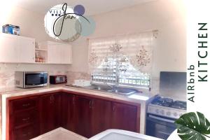 a kitchen with a sink and a microwave at Charming Villa in Ocho Rios in Ocho Rios