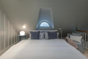 a bedroom with a large white bed with a window at Kampens Herzstück in Kampen
