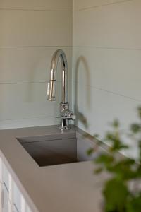 a kitchen sink with a silver faucet at Kampens Herzstück in Kampen +44 photos