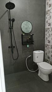 a bathroom with a shower with a toilet and a clock at Villa Kanaya in Sukapura