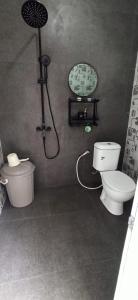 a bathroom with a shower and a toilet and a sink at Villa Kanaya in Sukapura +7 photos