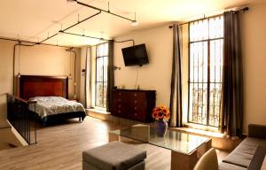 ein Wohnzimmer mit einem Bett und einem Tisch in der Unterkunft Studio Loft Corina in Morelia