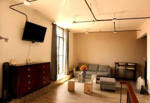 ein Wohnzimmer mit Couch und Fernseher in der Unterkunft Studio Loft Corina in Morelia